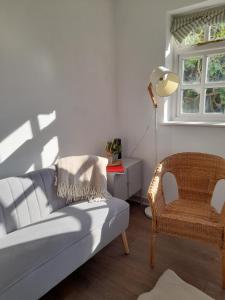 My Little Studio في Farmborough: غرفة معيشة مع أريكة وكرسي