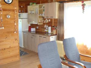 ヤロスワビエツにあるDomki u Uliのキッチン(青い椅子2脚、カウンター付)