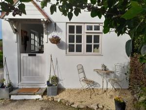 a white house with a table and chairs outside at My Little Studio in Farmborough