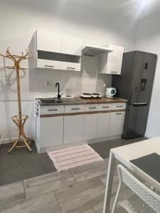 a kitchen with white cabinets and a stainless steel refrigerator at Apartament Wrzosowa in Kudowa-Zdrój
