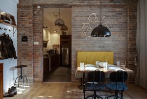 a dining room with a table and a brick wall at Hoodo Zoe - Hebbal Bangalore Apartments in Bangalore