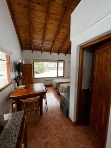 a room with a bed and a desk and a table at Schuss Cerro Catedral ARG41 in San Carlos de Bariloche