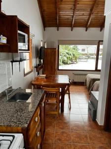 cocina con fregadero y mesa en una habitación en Schuss Cerro Catedral ARG41 en San Carlos de Bariloche