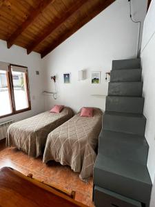 a bedroom with two beds and a staircase at Schuss Cerro Catedral ARG41 in San Carlos de Bariloche