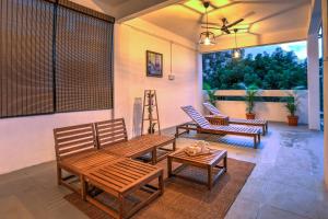 eine Terrasse mit Bänken, einem Tisch und einem Fenster in der Unterkunft Hoodo Zoe - Hebbal Bangalore Apartments in Bangalore