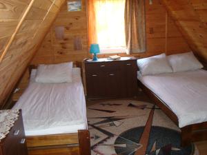 a bedroom with two beds in a log cabin at Domki u Uli in Jarosławiec