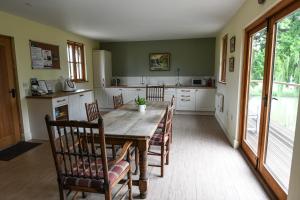 a kitchen with a long wooden table and chairs at SHEPHERDS HUT in Kent