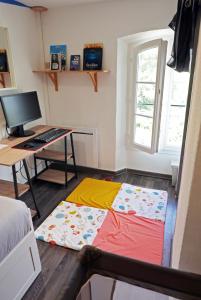 a bed on the floor in a room with a desk at Détente et sport 3 - Chartreuse et Lacs - Appartement entier in Saint-Béron