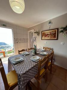 comedor con mesa con sillas y mantel en Tropical House, en Ribeira Brava