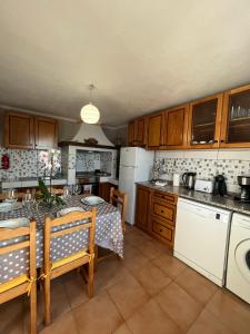 cocina con mesa y cocina con electrodomésticos blancos en Tropical House, en Ribeira Brava