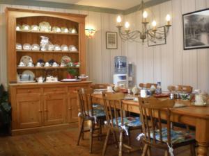 uma sala de jantar com uma mesa de madeira e cadeiras em Ilenroy House em Skibbereen