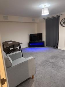 a living room with a couch and a table and a tv at 2 Bed Apartment Sleeps 5, Free Parking, Free Wifi, Spacious, Quiet, Close to Station, Restaurants & Shops, Contractors and Holidays in London