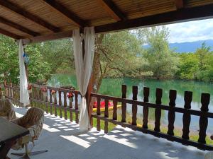 a porch with a view of a lake and a fence at River house Golac in Gospić