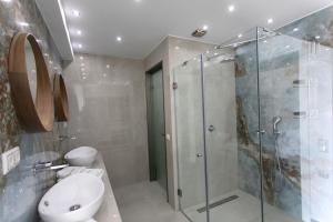 La salle de bains est pourvue d'une douche, de toilettes et d'un lavabo. dans l'établissement Goldeneye luxury Villas, à Parga
