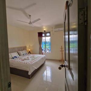 a bedroom with a bed and a window at Bird Beak Beach in Omadhoo