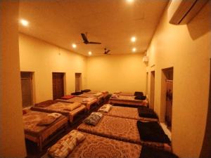 a row of beds in a room with a ceiling at Bequest Stays In Puri in Puri