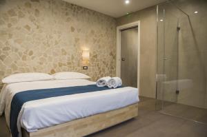 um quarto com uma cama e uma cabina de duche em vidro em suite 18 luxury apartments em Bari