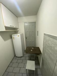 eine kleine Küche mit einem Tisch und einem Kühlschrank in der Unterkunft Flat Aeroporto vitoria in Vitória