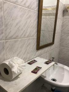 a bathroom with a sink and a toilet and a mirror at Pousada Mare Blue in Búzios