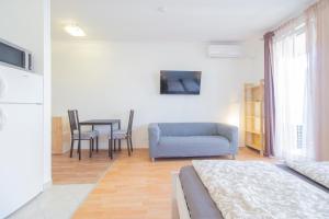 a living room with a blue couch and a table at Corvin Modern Studio with AC, Smart TV in Budapest