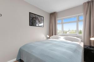 a white bedroom with a bed and a window at Reykjavík Central Guesthouse in Reykjavík