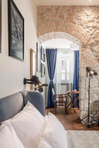 a living room with a couch and a stone wall at Photel studio Apartments in Crikvenica