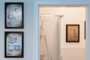 a shower in a bathroom with two pictures on the wall at Photel studio Apartments in Crikvenica +50 photos