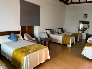 a hotel room with three beds and a table at Clarisas Suites in Carmona