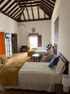 a bedroom with a bed and a living room at Clarisas Suites in Carmona