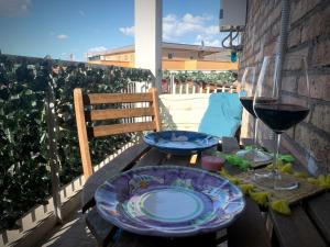 una mesa de madera con dos platos y una copa de vino en B&b Apartment Roma Centre, en Roma