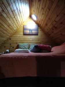 Ce lit se trouve dans un dortoir doté d'un plafond en bois. dans l'établissement Brvnara Ruska sauna, à Čajetina