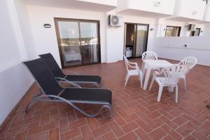 a living room with chairs and a table and a dining room at Apartamentos Mestret in San Antonio