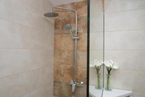 a shower with a glass door and a vase of flowers at Apartamentos Mestret in San Antonio