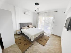 a bedroom with a bed and a large window at Your Go-to Place at Amwaj, North Coast for Summer! in El Alamein
