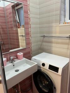 een badkamer met een wasmachine en een wastafel bij Vila Mateo in Sarandë