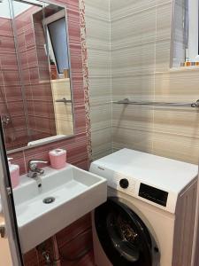 een badkamer met een wasmachine en een wastafel bij Vila Mateo in Sarandë