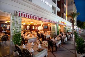 un restaurante con mesas con gente sentada en ellas en Xperia Grand Bali Hotel - All Inclusive en Alanya