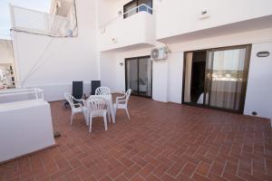 a room with a table and chairs on a brick floor at Apartamentos Mestret in San Antonio