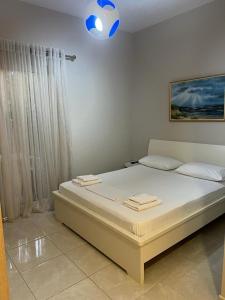 1 dormitorio con 1 cama grande y paredes blancas en Vila Mateo en Sarandë