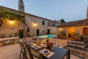 an outdoor patio with a table and a swimming pool at Villa San Vincenti in Svetvinčenat