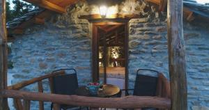 a table and chairs on the porch of a stone house at Aristoteli's Stone House in Makrirrákhi