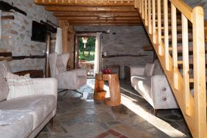 ein Wohnzimmer mit einem Sofa und einer Treppe in der Unterkunft Aristoteli's Stone House in Makrirrákhi