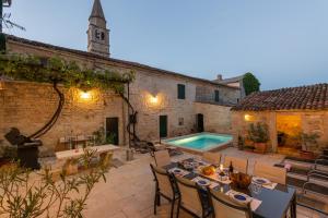 an outdoor patio with a table and a swimming pool at Villa San Vincenti in Svetvinčenat