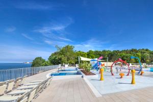 a pool with a playground next to the water at Drago Tours LODGE TENT Holiday Deluxe, Lanterna in Poreč