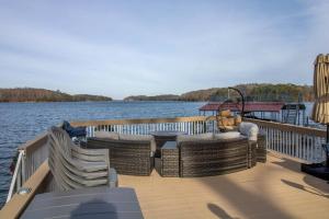 a dock with wicker chairs and tables on a boat at Luxurious Chalet over Margaritaville in Buford