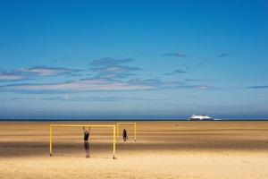 eine Person, die vor einem Tor an einem Strand steht in der Unterkunft Cottage autour de l'étang 79 in Bourbourg