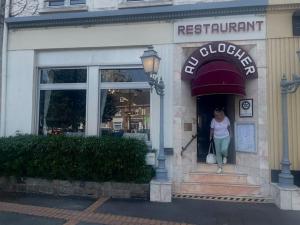 eine Frau, die aus dem vorderen Teil eines Restaurants kommt in der Unterkunft Cottage autour de l'étang 79 in Bourbourg