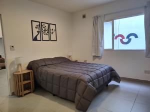 Un dormitorio con una cama grande y una ventana en Moderno PH con patio en Chacarita A 3 minutos de Palermo y 2 cuadras del Movistar Arena y Art Media, en Buenos Aires