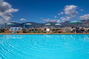 a woman laying in a swimming pool at Natur Resort Panorama in Malcesine