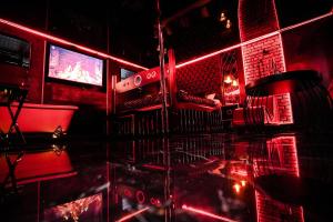 una habitación con un bar con luces rojas y una mesa en Grey Secret Champagne Apartament Spa en Gdansk